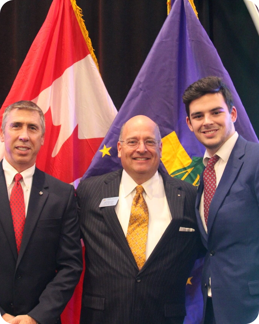 3 members in front of flags